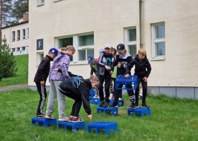 Lapset kisailevat Jäteselviytyjät-loppukilpailussa suonylitys-pisteellä.