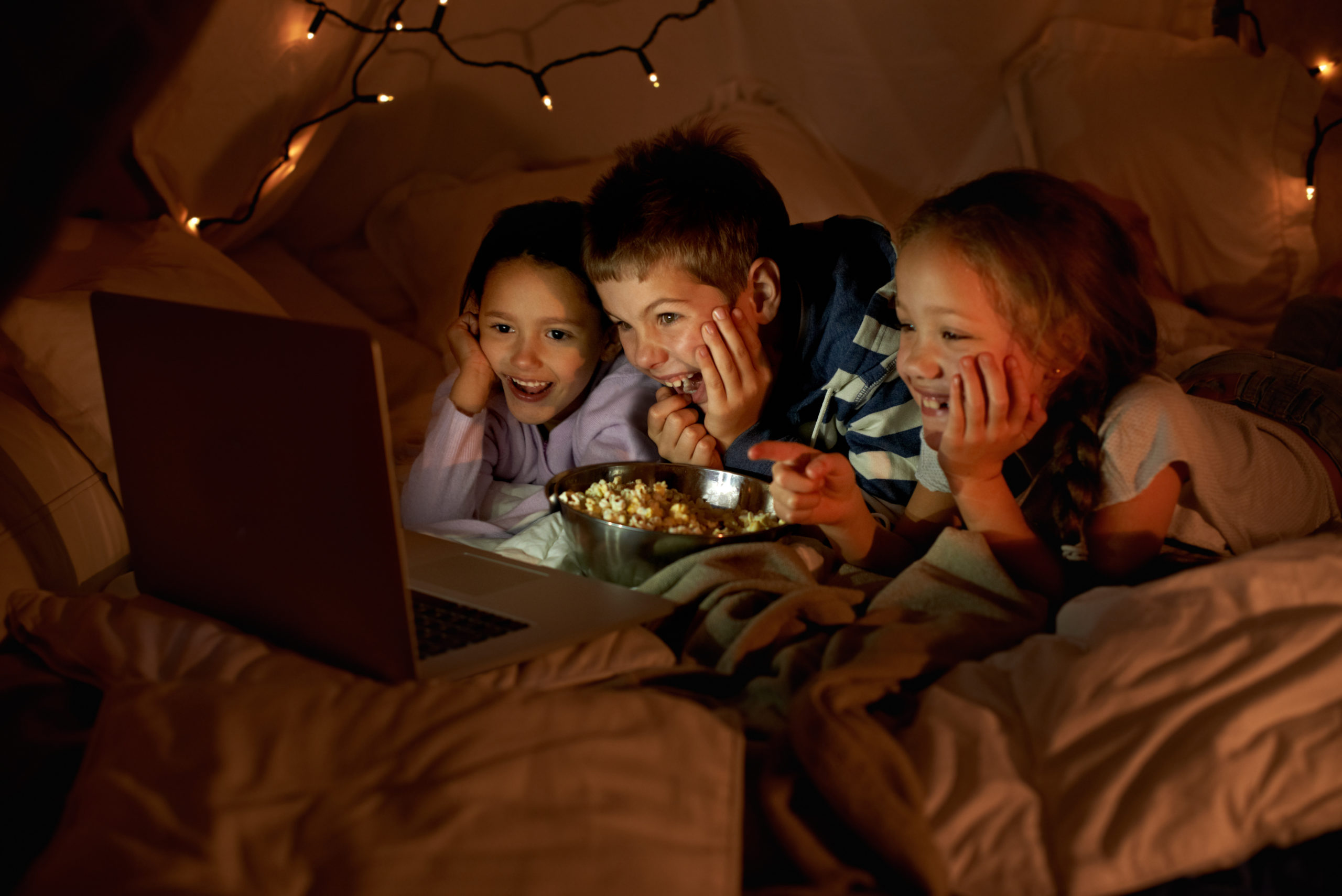 Kolme lasta katsoo elokuvaa tietokoneelta